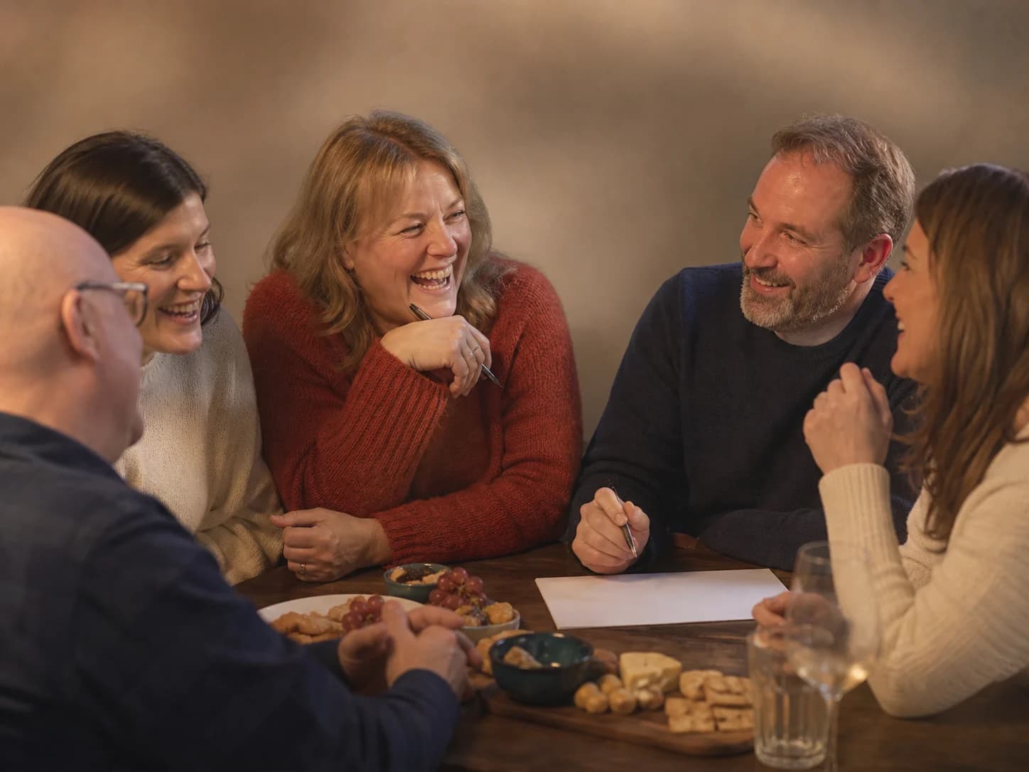Friends enjoying food and a relaxed table quiz together